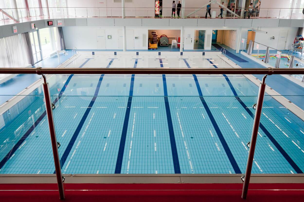 Een leeg zwembad gefotografeerd vanaf een ballustrade.