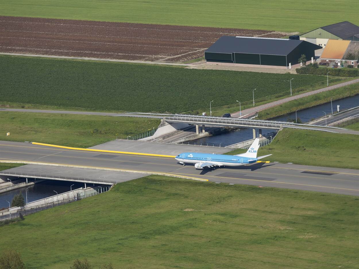 Een KLM-vliegtuig taxiet over een vliegveld.