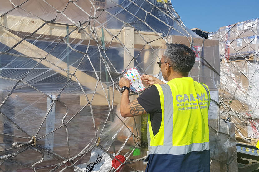 Een inspecteur controleert een lading op gevaarlijke stoffen.