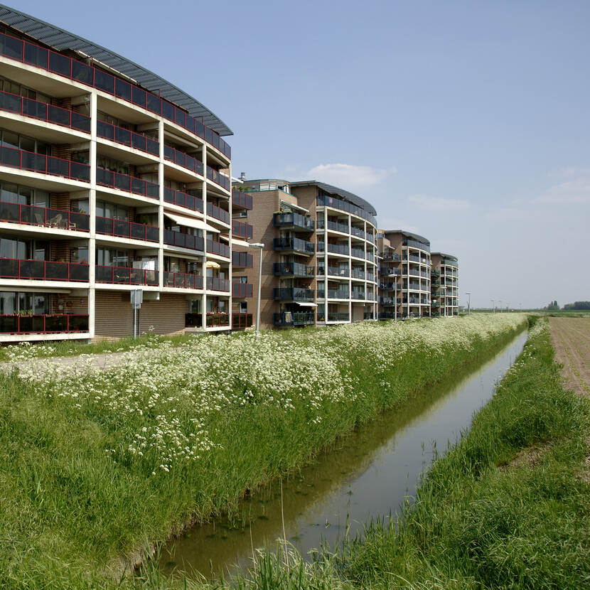 Een aantal appartementencomplexen in Spijkenisse. Voor de appartementen ligt een rechte sloot.