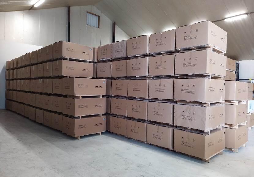 In een opslagloods ligt een partij airco's en warmtepompen in kartonnen dozen.
