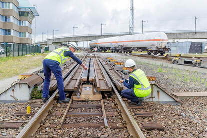 Twee railinspecteurs controleren het spoor.