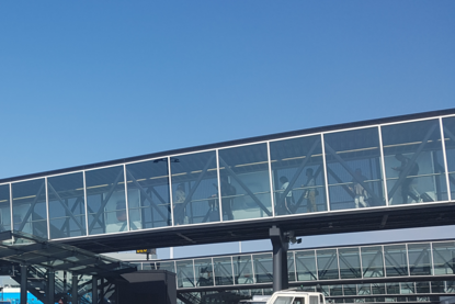 Luchtvaartpassagiers lopen door verbindingstunnel tussen luchthaven en vliegtuig.