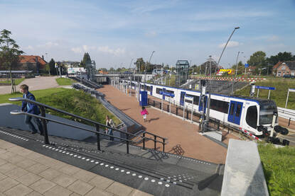 Een sprinter staat stil bij een station.