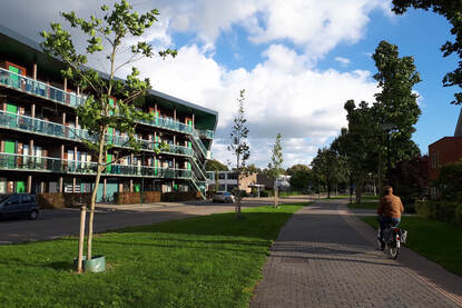 Een appartementencomplex in Odijk. Een fietser fietst over voorbij.