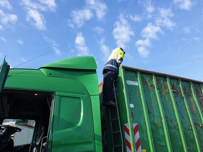 Een inspecteur controleert de lading van een vrachtwagen.
