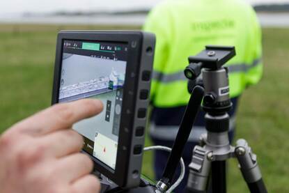 Een inspecteur bekijkt de beelden van een drone.