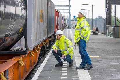 Twee inspecteurs controleren de lading van een trein.
