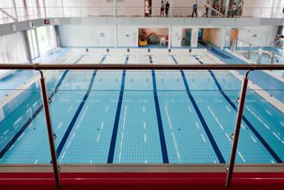 Foto van een leeg zwembad bezien vanaf de tribune.