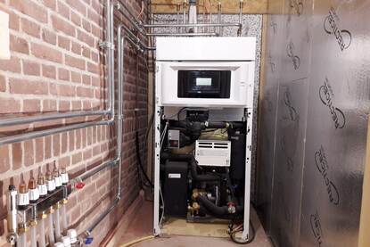 Warmtepomp ingebouwd in een geïsoleerde ruimte in of aan het huis.