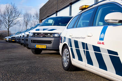 Meerdere inspectie auto's en bussen staan naast elkaar geparkeerd.